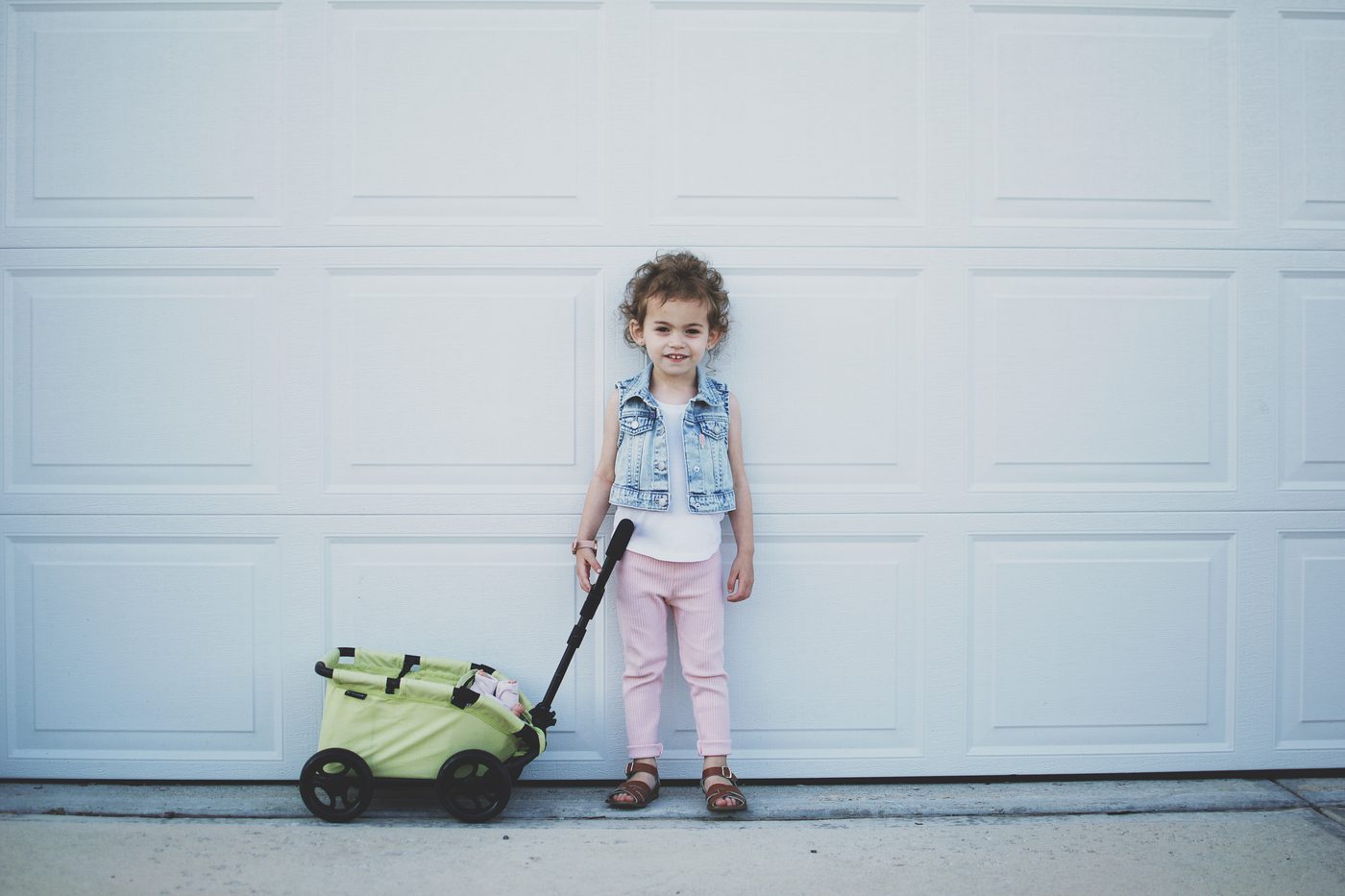 A young girl in a denim vest with her Triokid wagon
